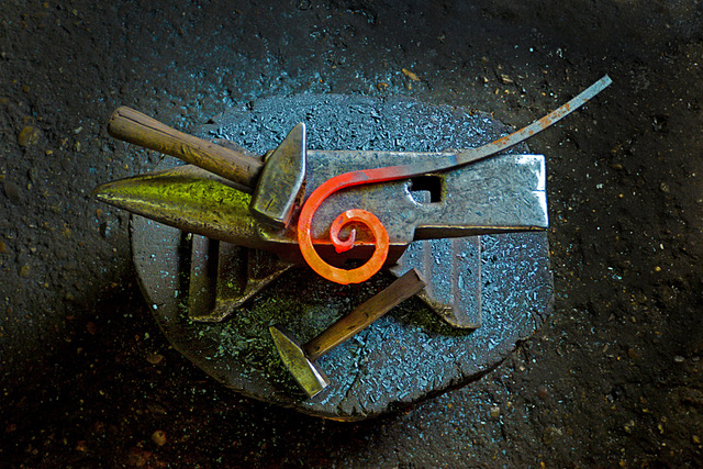 Image of The Forge's logo: a curled strip of red glowing heated metal laying atop an anvil next to a hammer.