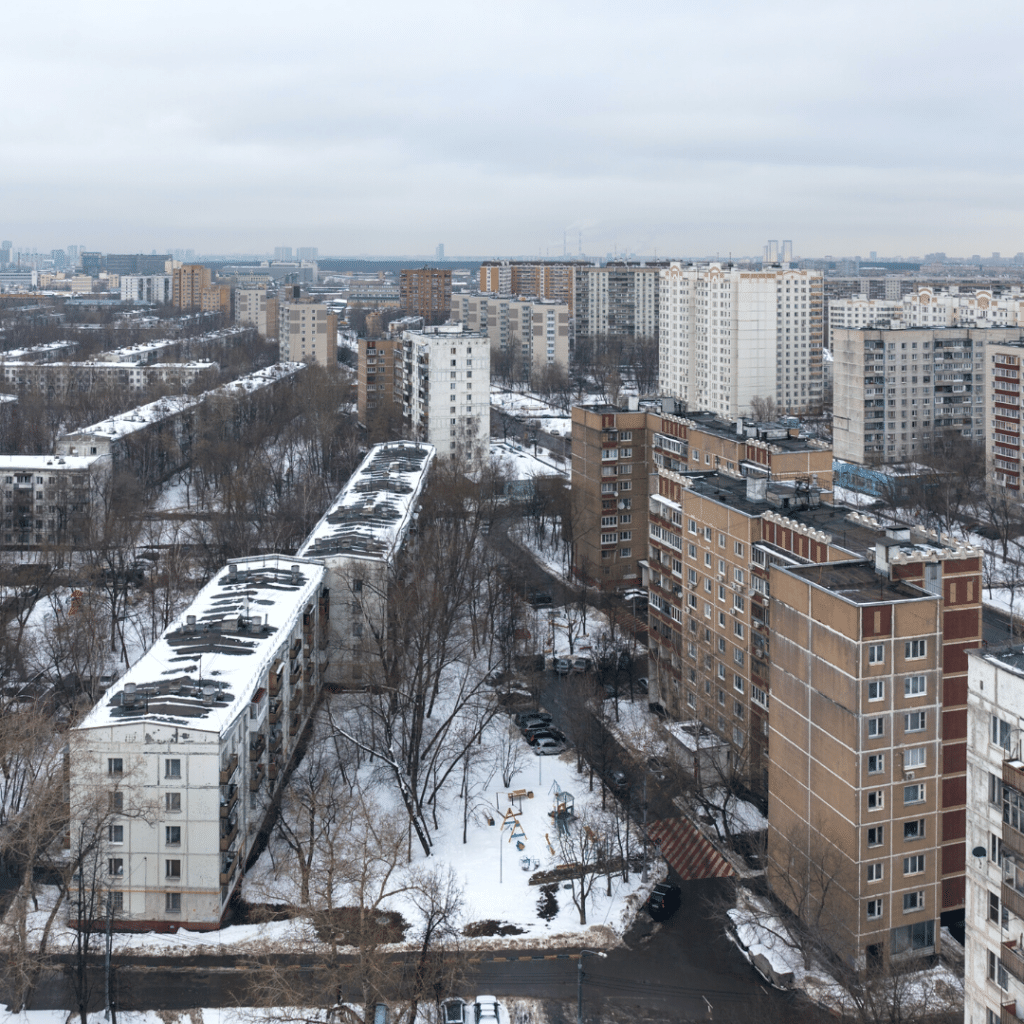 A view of a city district full of tower block buildings, covered in snow.