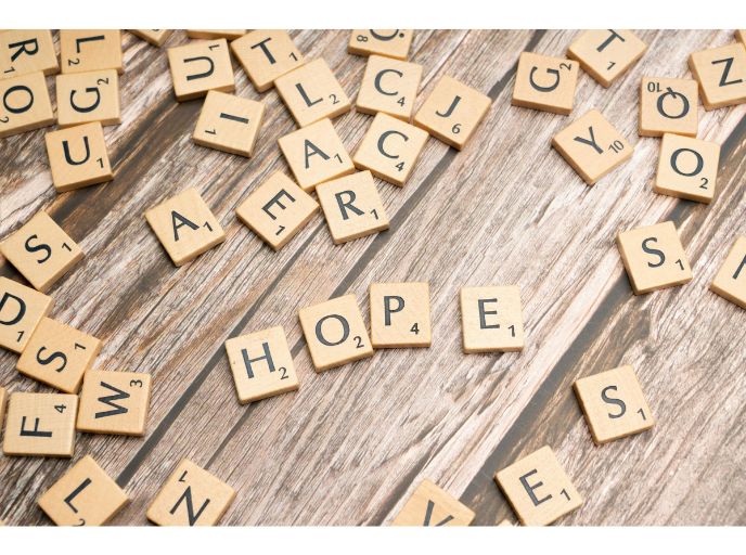 A table filled with scrabble letters with the word hope spelled out in the middle