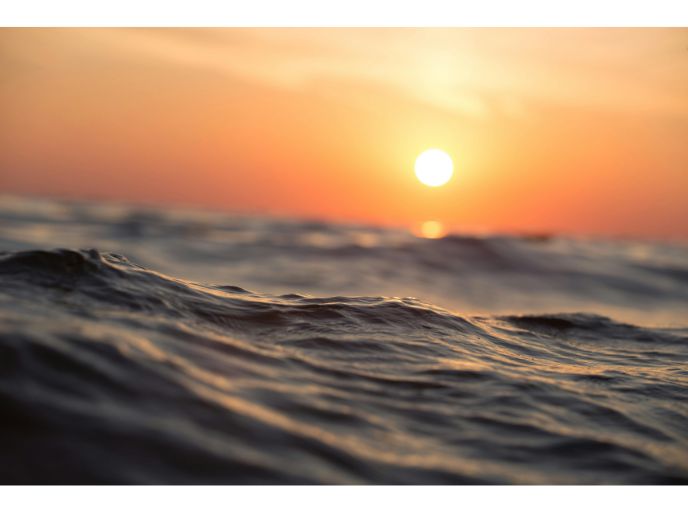 A golden hour sun above the ocean 