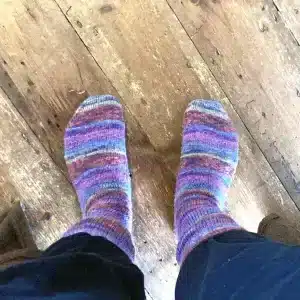 Cosy wooly socks hand-knitted by Sarah's mum, in purple, blue and sort-of-green stripes. They're rad.